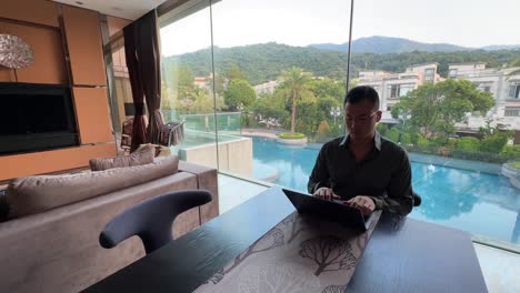 Asian-Millennial-Entrepreneur-Working-Remotely-in-a-Luxurious-Home-with-Pool-View