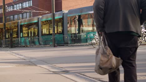 Shiny-new-electric-tram-commuter-train-drives-by-on-Helsinki-street