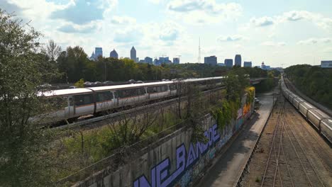 Aufsteigende-Drohnenaufnahme-Von-Zügen-Und-Autos-In-Einem-Vorort-Von-Atlanta-City-An-Sonnigen-Tagen