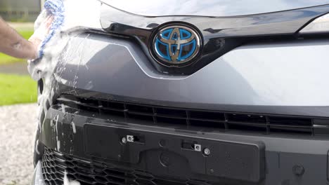 Washing-front-bumper-on-blue-silver-car