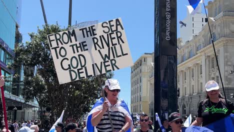 White-woman-dancing-and-holds-a-sign-at-protest-demonstration-in-city-square