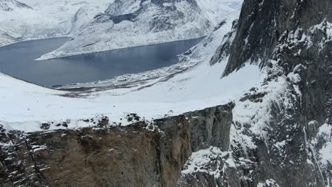Drohnenansicht-In-Der-Gegend-Von-Tromsø-Im-Winter-Beim-Flug-über-Einen-Schneebedeckten-Berg-Mit-Dem-Felsigen-Gipfel-Von-Segla-In-Segla,-Norwegen