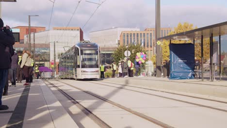Shiny-new-transit-tram-on-opening-day,-sunny-Helsinki-street-platform