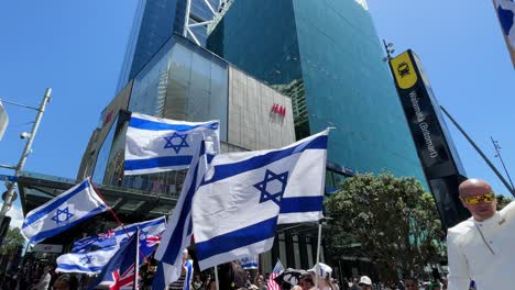 Los-Manifestantes-Sostienen-Banderas-De-Israel-Y-Nueva-Zelanda-En-Una-Protesta-Contra-Palestina.