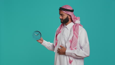 Islamic-adult-looks-at-wall-clock