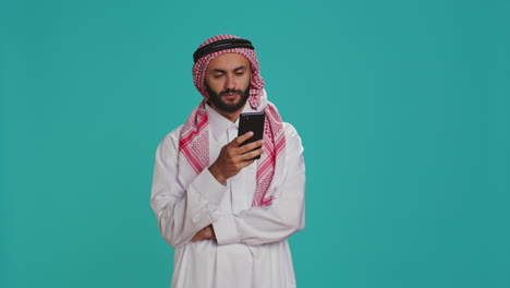 Muslim-man-in-costume-using-smartphone