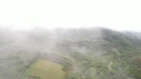 Luftaufnahme-Durch-Neblige-Wolken-über-Einem-Wunderschönen-Grünen-Tal,-Italien