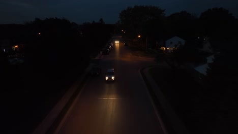 Cars-driving-in-American-neighborhood-at-night