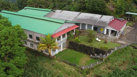 Drone-reveal-of-Seychelles-tea-factory-in-the-national-park,-Mahe-Seychelles