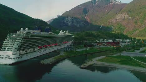 Avión-Teledirigido-En-Movimiento-Hacia-Adelante-Sobre-Un-Crucero-Atracado-En-El-Puerto-De-Flam-Rodeado-De-Montañas-En-El-Centro-De-Noruega-Durante-La-Mañana