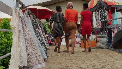 Mujer-Caminando-En-El-Mercado-De-Adum-Ropa-Tradicional-Local-Establecido-Tiro-De-ángulo-Bajo