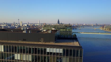An-accent-drone-shot-from-the-Rheinauhafen-to-the-city-scape-of-Cologne,-Germany