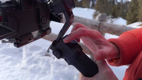 Nahaufnahme-Von-Fingern,-Die-Draußen-Auf-Den-Gimbal-Bildschirm-Tippen,-Während-Schnee-Auf-Dem-Boden-Liegt