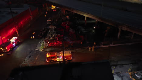 Aerial-view-over-firefighters-at-a-pallet-fire-aftermath-at-interstate-10,-in-Los-Angeles,-USA