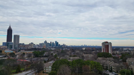 Aerial-tilt-up-shot-of-Atlanta-City-Suburb-with-Skyline-in-Downtown-at-cloudy-day