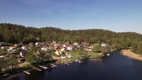 Acercamiento-A-Una-Toma-De-Drones-De-Un-Pequeño-Pueblo-Cerca-De-Un-Lago-En-Suecia