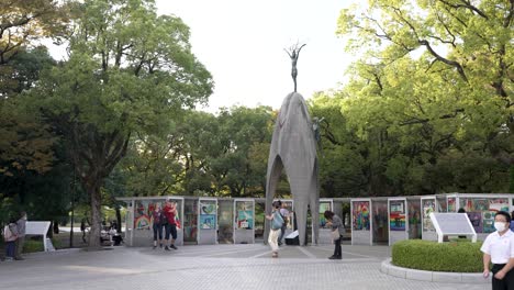 Turistas-Que-Visitan-El-Monumento-A-La-Paz-De-Los-Niños-En-Hiroshima-En-Una-Tarde-Soleada