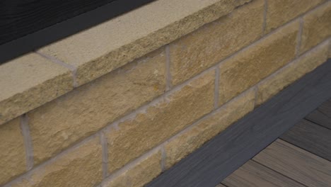 Close-up-of-luxury-sandy-stone-brick-work-on-a-low-hung-wall-in-modern-new-back-garden