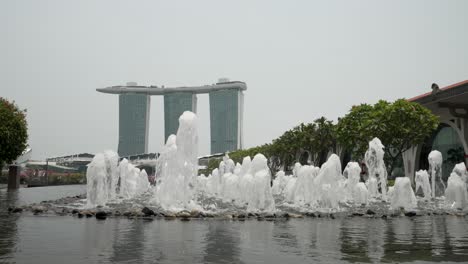 Fuente-Fullerton-Con-Vistas-Al-Hotel-Marina-Bay-Sands-Al-Fondo-En-Un-Día-Nublado-En-Singapur