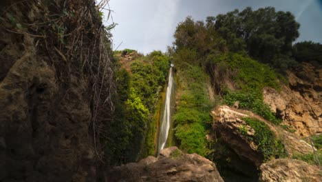Schöner-Wasserfall-Und-Grüne-Felsige-Umgebung,-Zeitraffer