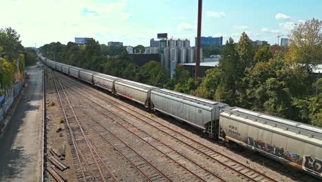 Aerial-panning-shot-of-train-stopped-at-railroad-in-Atlanta-City-during-sunny-day