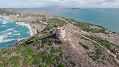 Torre-di-San-Giovanni-di-Sinis,-Sardinia:-fantastic-aerial-view-in-a-circle-over-the-famous-tower-and-overlooking-a-spectacular-coastline-with-turquoise-waters