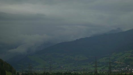 Nube-De-Grises-Y-Niebla-Blanca-Rodando-Sobre-El-Paisaje-Debajo