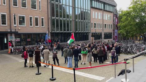 Manifestante-Ondeando-Bandera-Palestina-Durante-La-Manifestación-Pro-Palestina,-Estudiantes-Protestando-Por-La-Franja-De-Gaza