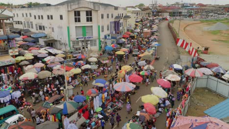 Toma-Aérea-Establecida-Del-Mercado-Tradicional-En-África-Con-Productos-Textiles-Y-Locales,-Carretera-Concurrida-Y-Concurrida-Paisaje-Urbano-Africano