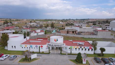 Una-Impresionante-Vista-De-Drone-Muestra-Un-Hermoso-Y-Colorido-Centro-De-Rehabilitación-Con-Una-Hermosa-Ciudad,-Ecatepec-De-Morelos,-México