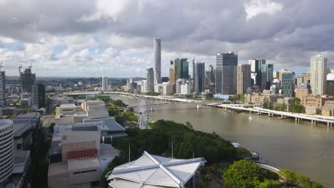 Panoramic-aerial-establishing-overview-of-ferris-wheel-in-Brisbane-river,-Australia