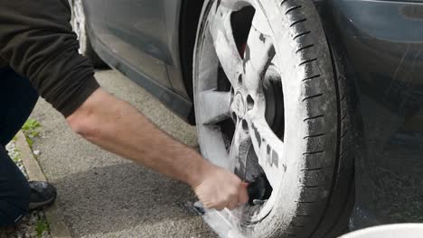 Cleaning-a-silver-wheel-on-a-black-car