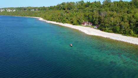 Aerial-view-of-a-waterfront-home-on-Lake-Huron-as-a-kayaker-paddles-past