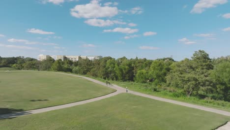 Una-Vista-Aérea-De-Una-Joven-Dando-Un-Paseo-Por-El-Parque-Eleanor-Tinsley-En-Un-Día-Soleado-Con-Nubes-Blancas-En-Houston,-Texas.