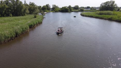 Aerial-backward-establisher,-riding-a-boat-on-river-Biesbosch-in-the-Netherlands