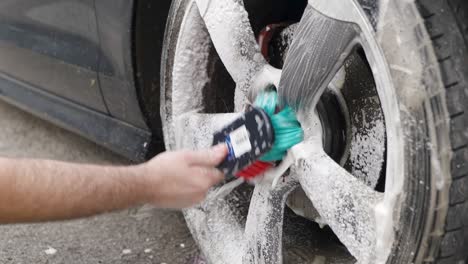 Cleaning-a-silver-wheel-on-a-black-car