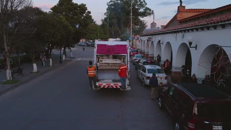 In-Ecatepec-de-Morelos,-Mexico,-a-municipal-employee-is-utilizing-the-garbage-truck-to-collect-waste-throughout-the-town