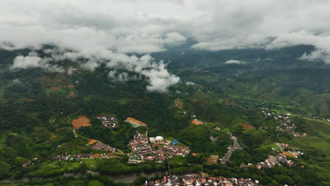 Aerial-view-of-San-Rafael-town-in-middle-of-mountains-and-low-clouds,-in-Colombia