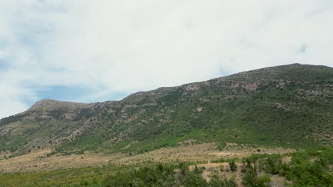 Vista-Panorámica-De-Montañas-Y-Campos-Con-Cielo-Nublado