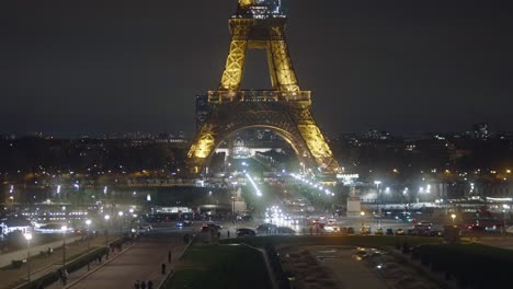 Der-Mitten-In-Der-Nacht-Beleuchtete-Eiffelturm-Und-Die-Lichter-Der-Vorbeifahrenden-Autos