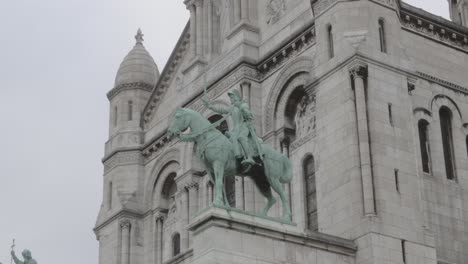 A-large-building-with-a-statue-of-a-horse-and-rider-on-top