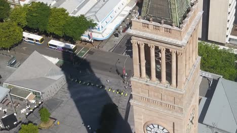 Large-city-hall-clock-tower-cast-long-shadow-on-pedestrians-in-Brisbane-Australia