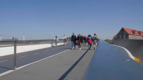 City-dwellers-stroll-across-a-modern-bridge-in-Copenhagen,-Denmark