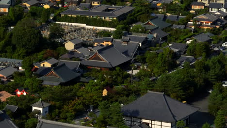 Toma-Aérea-De-Teleobjetivo-Inclinándose-Sobre-Los-Templos-Y-El-Paisaje-Urbano-De-Arashiyama,-Kyoto,-Japón