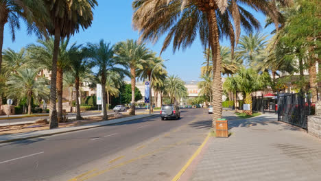 Walking-along-Aqaba-boulevard,-cars-passing-by,-Jordan
