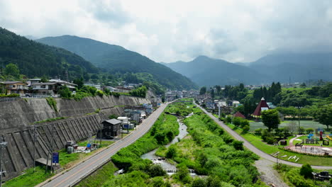 Aerial-view-following-the-Yokoyu-river,-summer-day-in-Yamanochi,-Japan