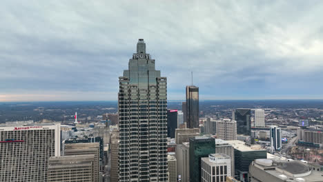 Panoramic-aerial-view-of-an-American-skyscraper-Truist-Plaza-highest-signage,-Downtown-Atlanta-skyline-buildings-and-cityscape-under-cloudy-sky