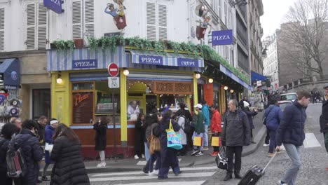 Pizzería-En-La-Esquina-De-París,-Muchos-Peatones-Caminando-Por-La-Calle-En-Pleno-Invierno