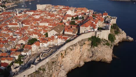 People-sightseeing-medieval-fortification-and-city-walls-of-dubrovnik-old-town,-Aerial