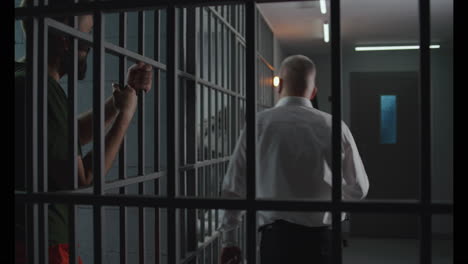 Gefängniswärter-Gibt-Dem-Gefangenen-Essen-Durch-Metallstangen-(Stockvideos)